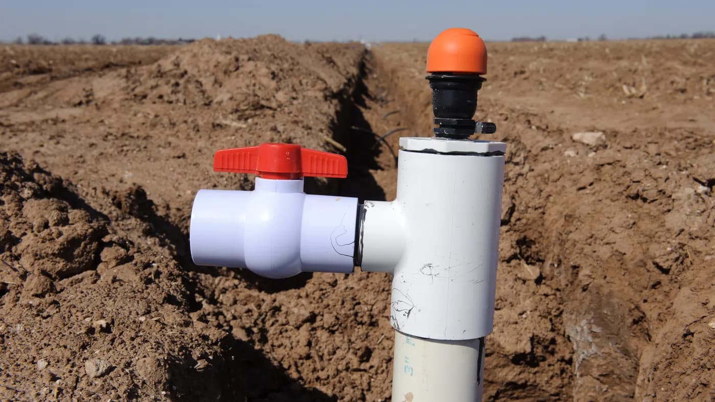 A red-handled irrigation shut-off valve installed beside a trench at Blake Davis Farms in Texas