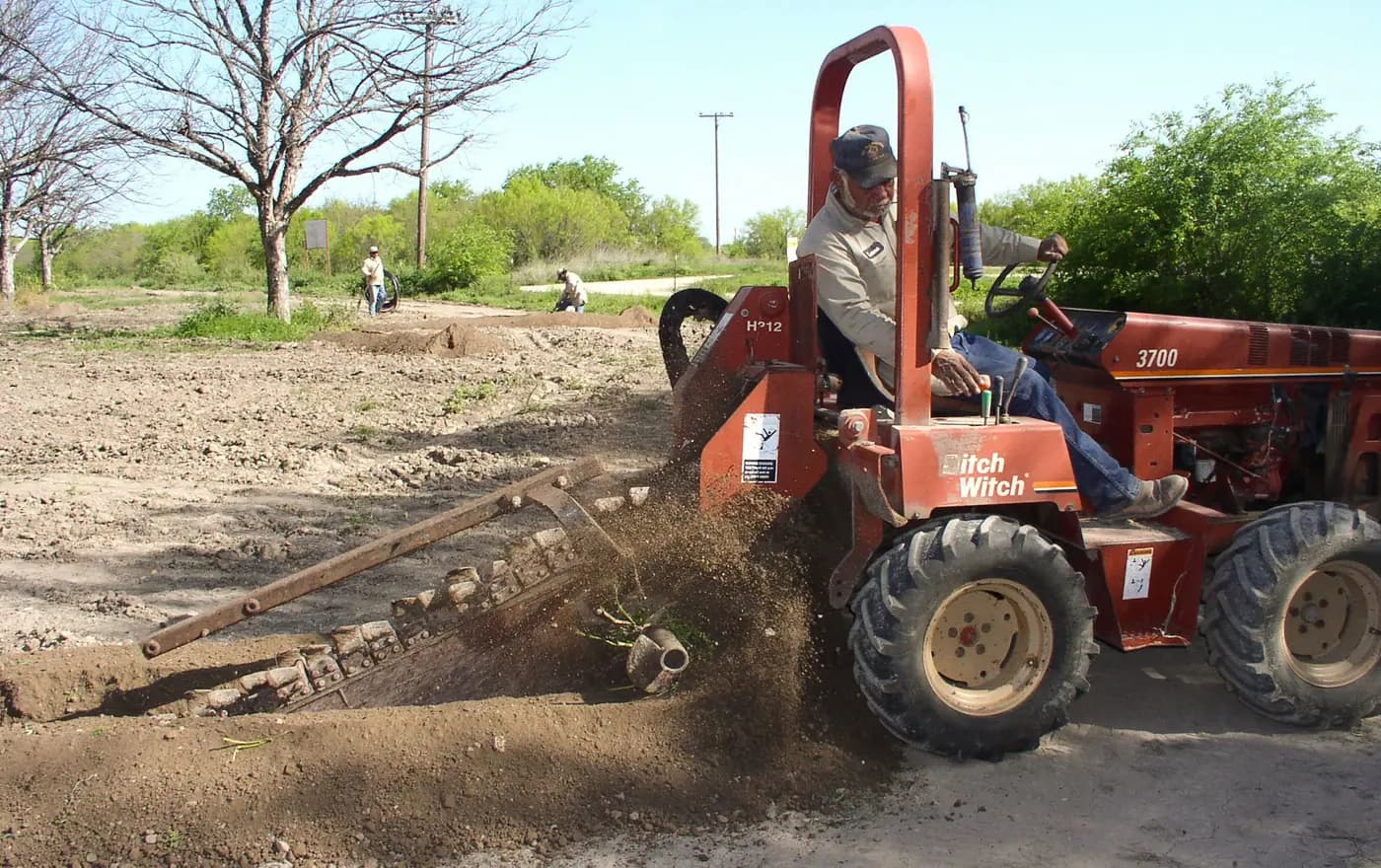 Trenching equipment preparing an underground irrigation route in a pecan orchard in Texas