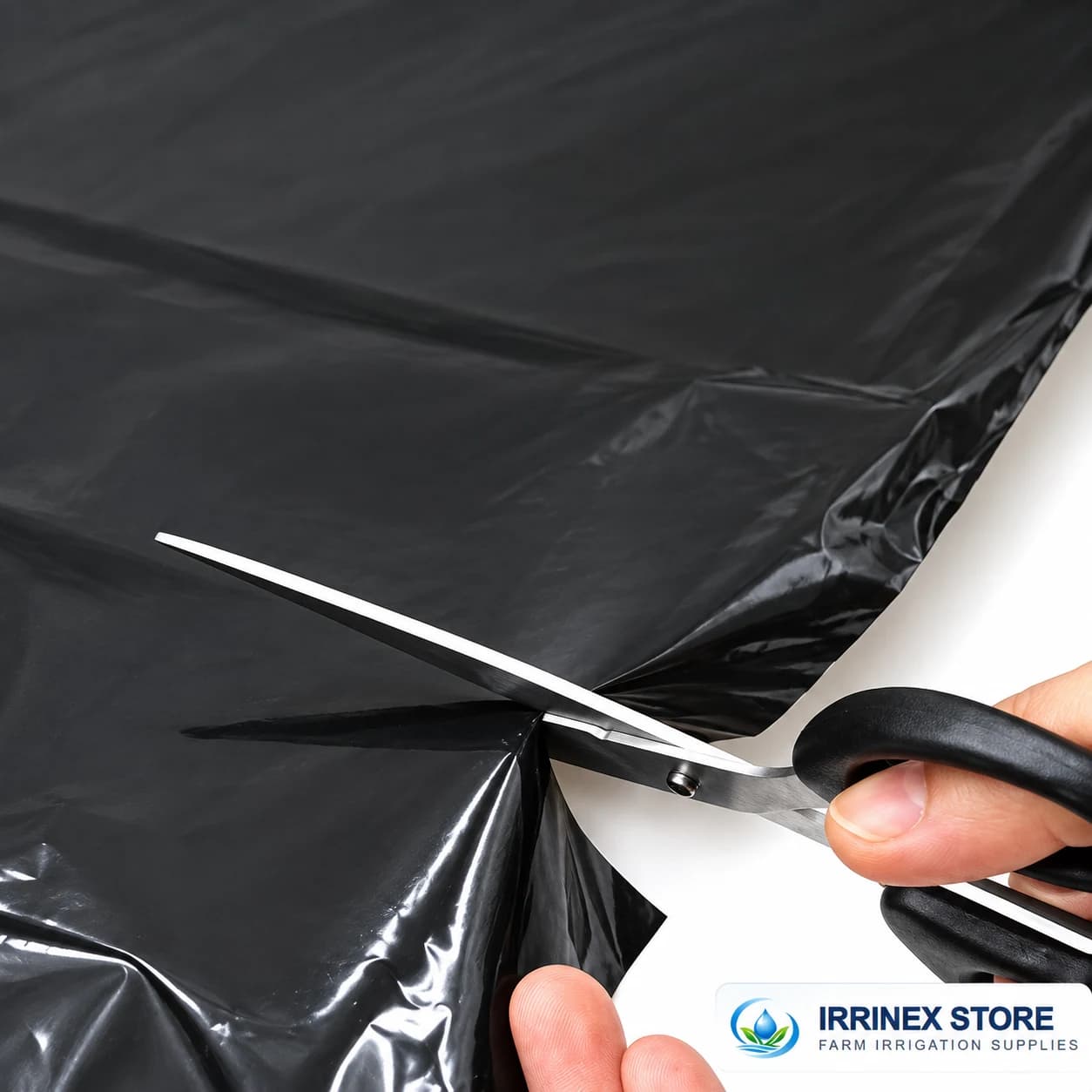 Black polyethylene sheet being cut to fit with scissors
