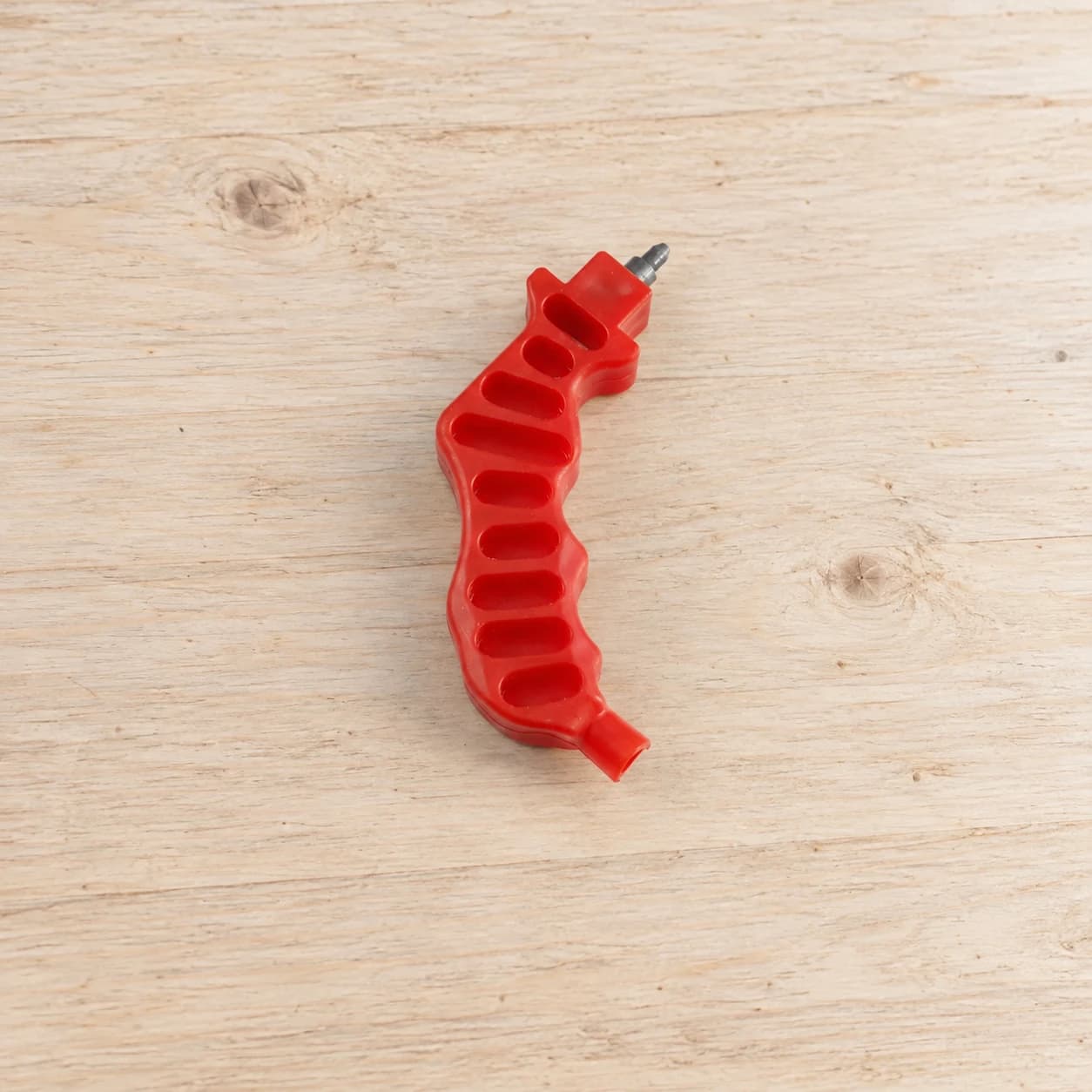AI-enhanced red 3mm hand punch on a neutral workbench; illustrative setting